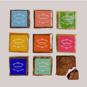eight Carolina's brownies with colourful labels on them and one opened brownie with a piece cut off